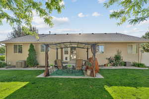Rear view of house featuring roof with shingles and a patio