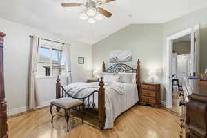 Bedroom with lofted ceiling, light wood-style floors, and a ceiling fan