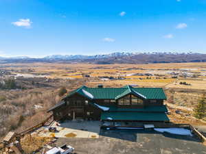 View of front of home featuring a view of countryside, a deck with mountain view, stairs, and a metal roof