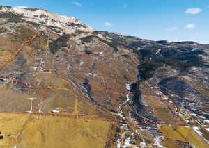 Aerial view of property and surrounding area featuring property parcel outlined and a mountain backdrop