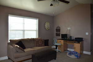 Office with light colored carpet, lofted ceiling, and a ceiling fan