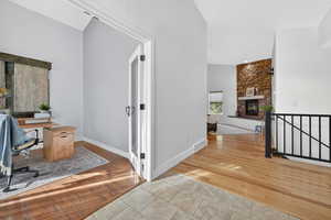 Office space with light wood floors and a fireplace