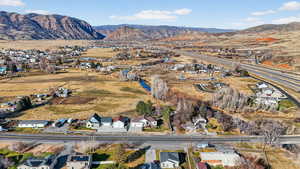 Aerial view of property's location featuring a mountainous background and nearby suburban area to the north west