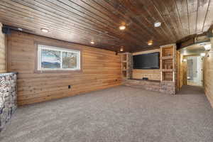 living room featuring wooden walls, wooden ceiling, carpet, and recessed lighting