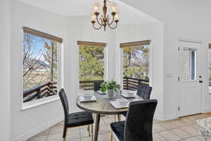 Dining area with a chandelier and light tile  floors