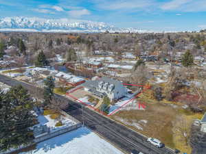 Snowy aerial view with property parcel outlined, a residential view, and a mountain view