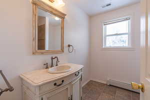 Bathroom with baseboard heating and vanity