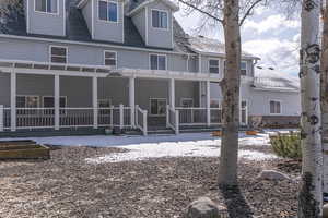 Snow covered property with roof with shingles