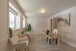 Office space with a textured ceiling, light tile patterned floors, and ornamental molding