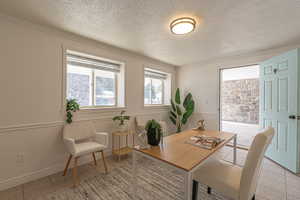 Dining area with a textured ceiling and crown molding