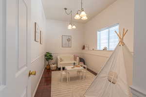 Living area with dark wood-style flooring and a chandelier