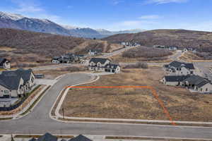 Aerial perspective of suburban area featuring property boundaries highlighted and a mountainous background