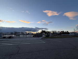 Uncovered parking lot featuring a tennis court