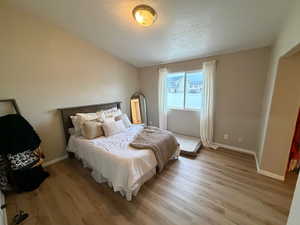 Bedroom featuring light wood-style floors and a textured ceiling