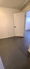Unfurnished room with concrete floors and baseboards