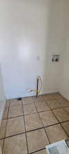 East Laundry area featuring washer hookup and light tile patterned flooring