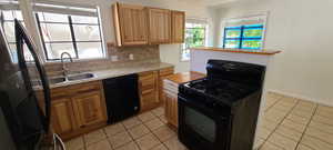 East Kitchen with black appliances, light tile patterned floors, tasteful backsplash, and brown cabinetry