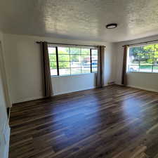 East living room with a textured ceiling and dark wood finished floors