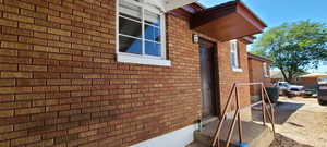 View east unit back entrance with brick siding and entry steps