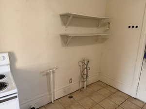 Laundry room with baseboards and light tile patterned floors