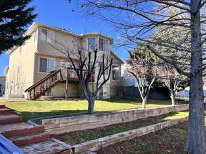Back of property with stairway, a deck, and stucco siding