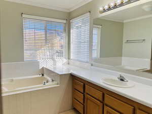 Full bathroom with a bath, crown molding, and vanity