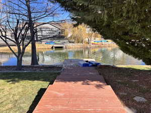 Dock with a water view and a yard