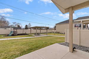 Fenced backyard with a playground, a patio, and a gazebo