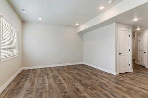 Basement with dark wood-type flooring and recessed lighting