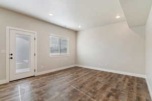 Empty room with dark wood-type flooring, recessed lighting, and a textured ceiling