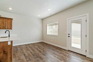 Unfurnished dining area with dark wood-style floors, recessed lighting, and a textured ceiling