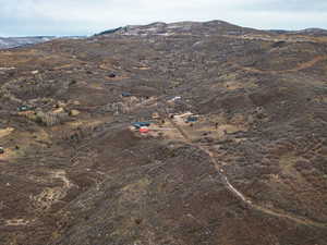 Aerial view of property and surrounding area featuring a mountain backdrop and rural landscape