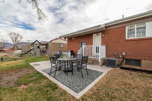 View of patio featuring a playground, grilling area, and outdoor dining space