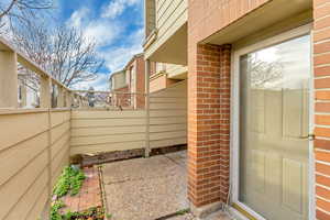 Entrance to property with brick siding and patio