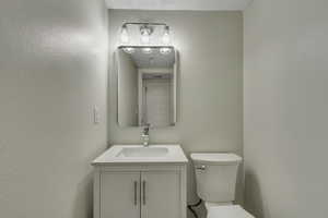 Half bathroom with vanity and toilet