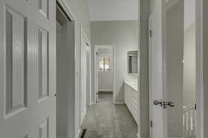 Primary bathroom featuring a vanity and light carpet