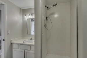 Hall bathroom with vanity and a stall shower