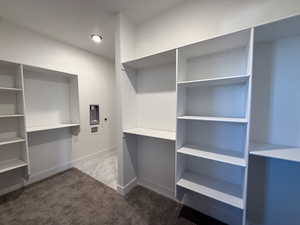 Walk in closet featuring dark carpet