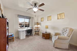 Office space featuring light carpet and a ceiling fan