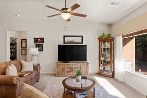 Living room featuring carpet, ceiling fan, and lofted ceiling