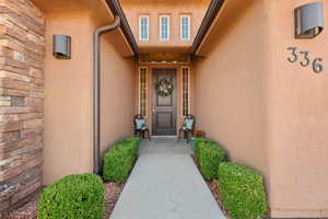 View of exterior entry with stucco siding and a porch