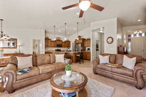 Living room with a chandelier, vaulted ceiling, a ceiling fan, light carpet, and recessed lighting