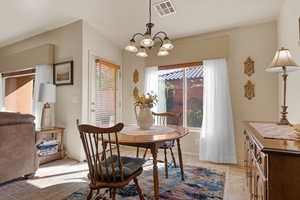Dining room featuring a chandelier and stone tile floors