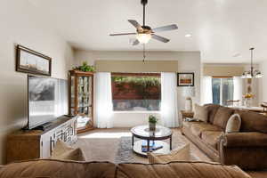 Living room with a chandelier, a ceiling fan, and carpet