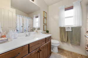 Bathroom with vanity, a shower with curtain, and lofted ceiling