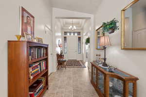 Foyer featuring a raised ceiling and a chandelier