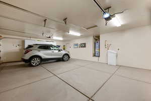Garage featuring strapped water heater and a garage door opener