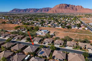 Aerial view of property and surrounding area with nearby suburban area and a mountainous background