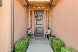 View of exterior entry featuring stucco siding and a porch