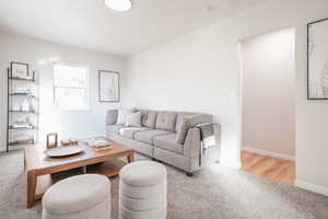 Living area with light carpet and baseboards